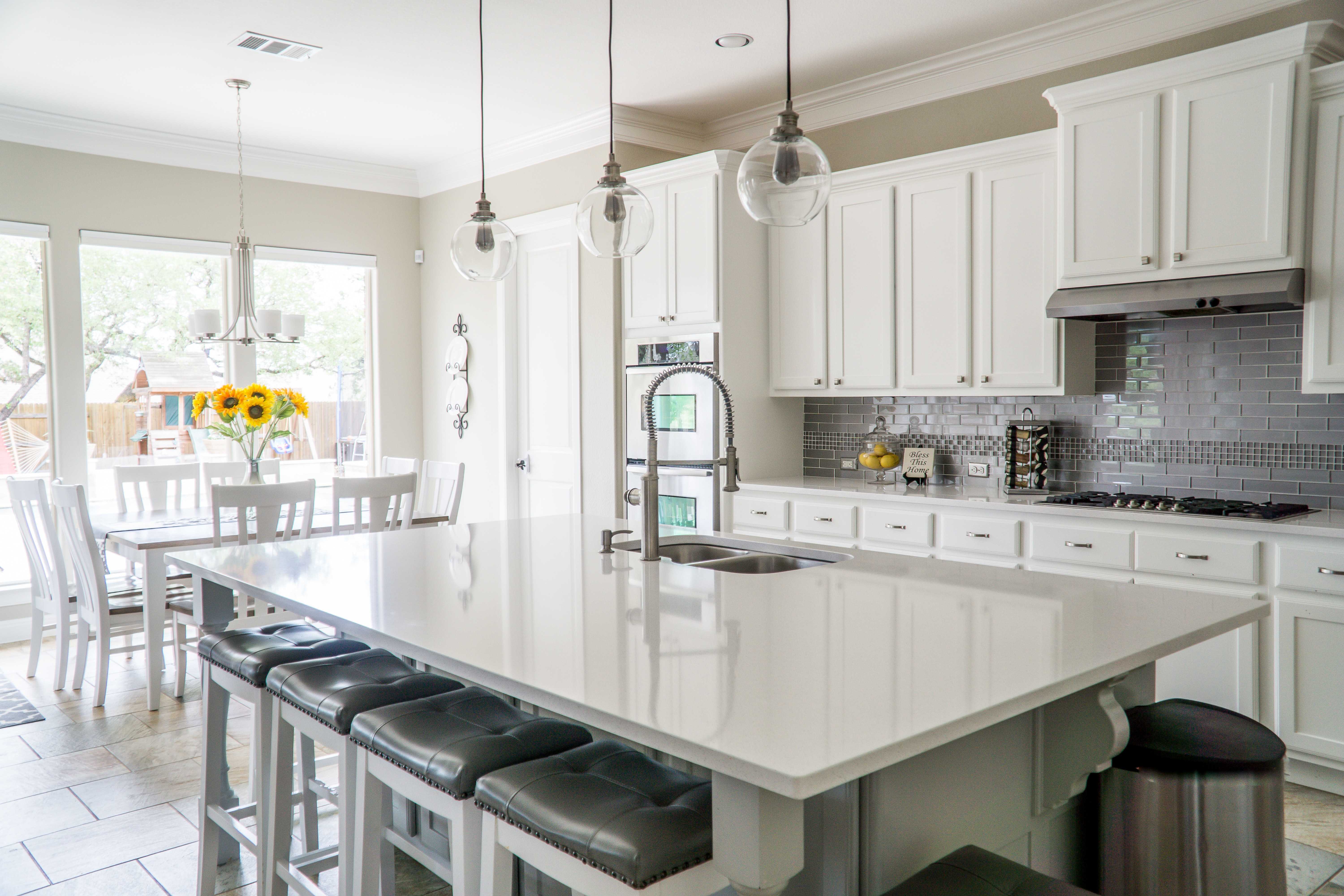 A black and white background of a kitchen situated in a large renovated home