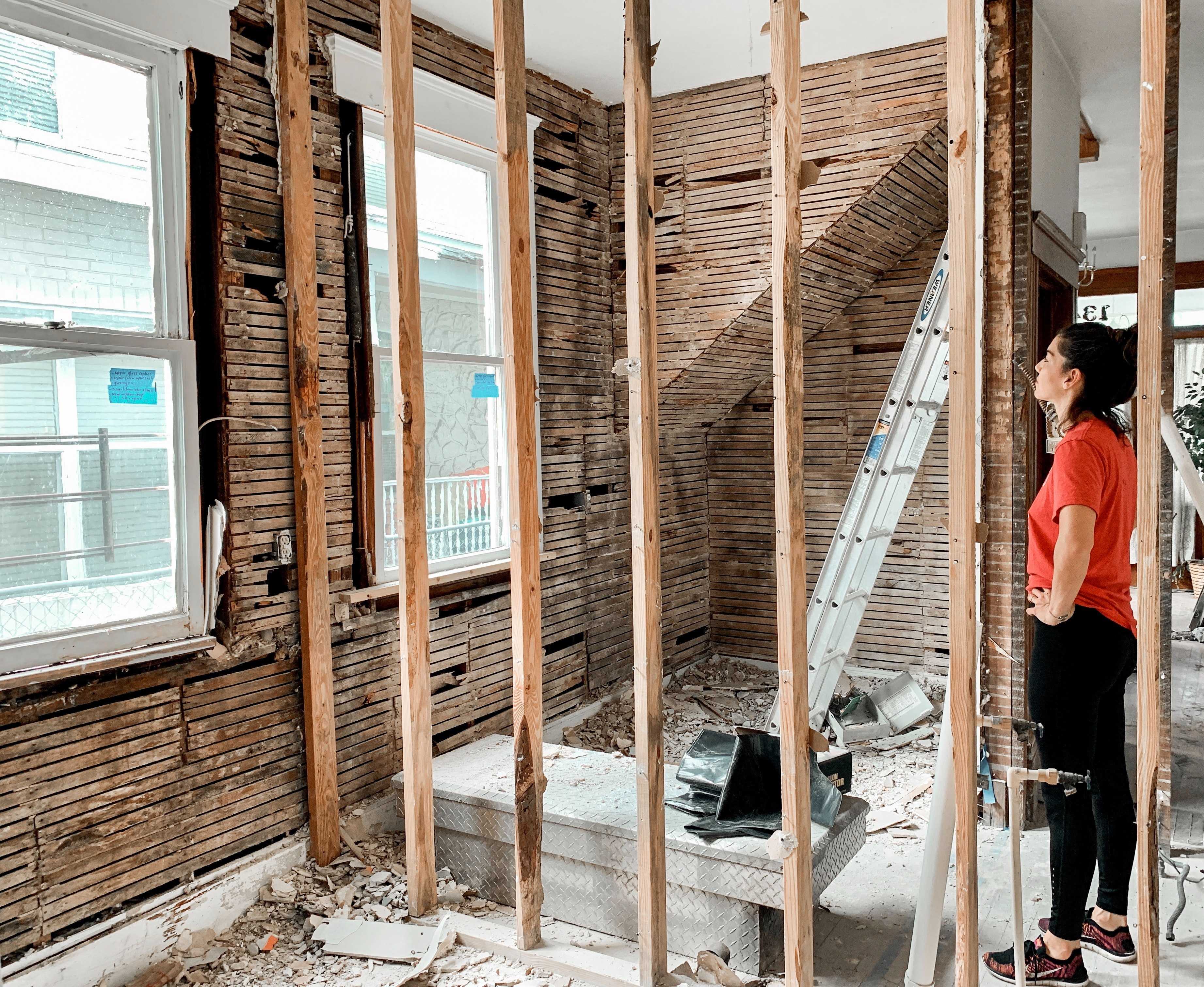 A black and white background of a woman staring out the window in a construction site